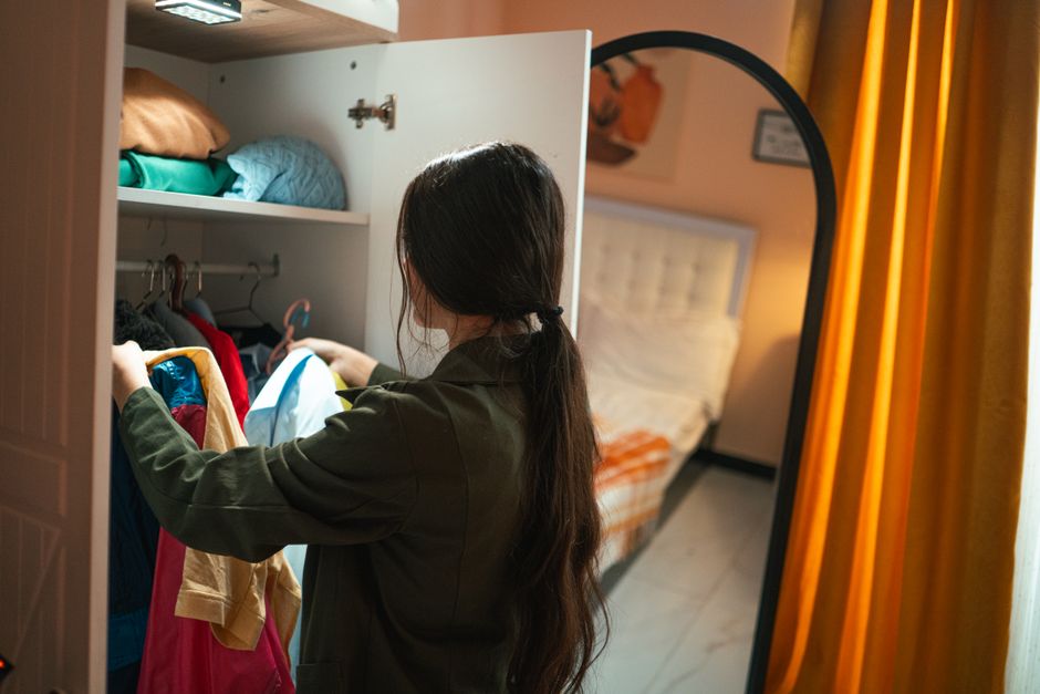 Person organizing clothes in a custom wardrobe